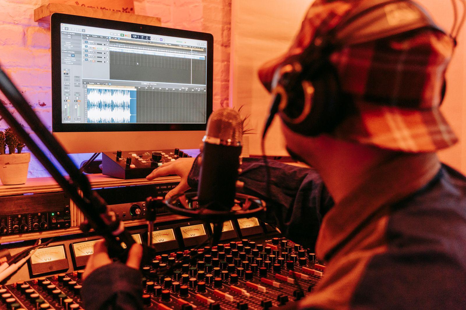 Producent med hörlurar som arbetar i studion
