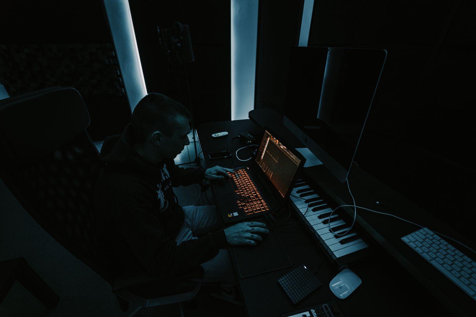 Producent som visar musikproduktion för en elev vid studiomixern